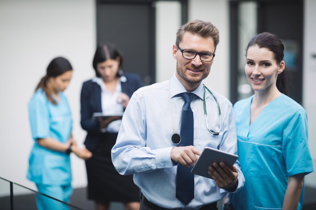 A doctor and nurse review information on a digital tablet