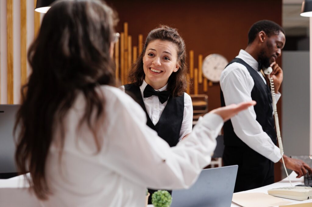 A concierge assists a guest with check-in at a hotel