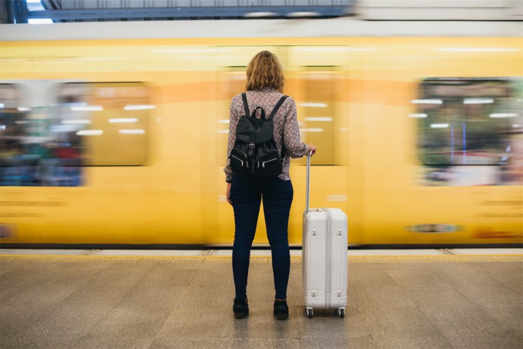 The picture shows a young woman with a suitcase in a train station. She wants to get on the train. But the train just passes by.