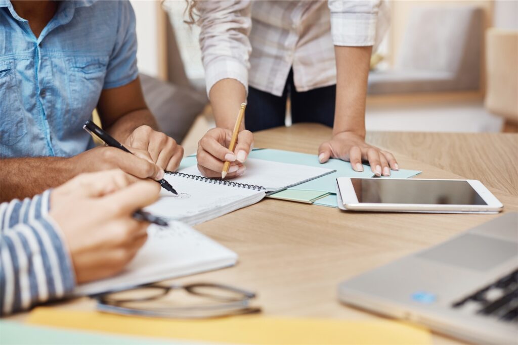 The picture shows employees working on their learning content with tablet and notebooks. Transform your Sales Team with technology!